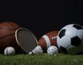 Sports equipment, rackets and balls on green grass with black background and copy space