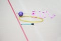 Sports equipment for rhythmic gymnastics lie on the edge of the carpet in the gym. Rhythmic gymnastics clubs, a ball, a hoop Royalty Free Stock Photo