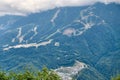 Sports facilities and residential buildings on the slope of a high mountain with a green slope and the top in the clouds. A sports Royalty Free Stock Photo