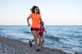 Sports family: morning jogging along the beach