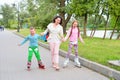 Sports family-mother with children on roller skates in the Park