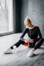 Sports female sits on floor and listens to music Royalty Free Stock Photo