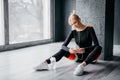 Sports female sits on floor and listens to music Royalty Free Stock Photo