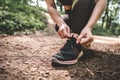 Sports female tying shoelaces on sneakers before jogging outdoor