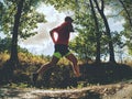 Sports figure man is running in the park alley in Sunny morning. Royalty Free Stock Photo