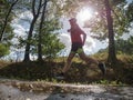 Sports figure man is running in the park alley in Sunny morning Royalty Free Stock Photo