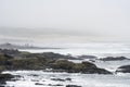 Sports fishermen in a foggy and rocky coast