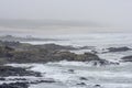 Sports fishermen in a foggy and rocky coast