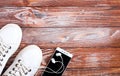 Sports flatlay with white sneakers, earphone and phone on wooden background. Concept healthy lifestyle. Top view. Copy space Royalty Free Stock Photo