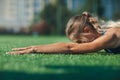 Sports girl in a blue shirt and leggings doing gymnastics workout on a football field. Fitness, sport, health energy. Close up. Royalty Free Stock Photo