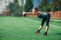 Sports girl in a blue shirt and leggings doing gymnastics workout on a football field. Fitness, sport, health energy. Royalty Free Stock Photo