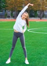 Sports girl doing morning gymnastics workout on a football field. Fitness, sport, health energy. Royalty Free Stock Photo