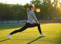 Sports girl doing morning gymnastics workout on green grass. In the control of warm sunlight. Fitness, sport, health, energy. Royalty Free Stock Photo