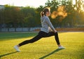 Sports girl doing morning gymnastics workout on green grass. In the control of warm sunlight. Fitness, sport, health, energy. Royalty Free Stock Photo