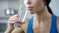 Sports girl drinking crystal clear water, restoring aqua balance after training