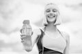 Sports girl drinks water from a bottle on a sky background. Drinking during sport. Black and white Royalty Free Stock Photo