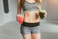 Sports girl after exercise relaxes in a bright room and cocktail drinks