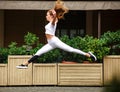 Sports girl gymnast jumping in flight at facade of street house Royalty Free Stock Photo