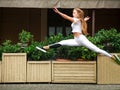 Sports girl gymnast jumping in flight at facade of street house Royalty Free Stock Photo