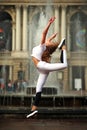 Sports girl gymnast jumping in flight on street of old city Royalty Free Stock Photo