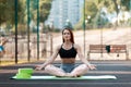 Sports girl meditates. The red-haired girl goes in for sports on the street. Yoga coach