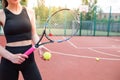 Sports girl is preparing to serve a tennis ball. Close-up of a beautiful young girl holding a tennis ball and racket Royalty Free Stock Photo