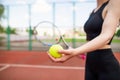 Sports girl is preparing to serve a tennis ball. Close-up of a beautiful young girl holding a tennis ball and racket Royalty Free Stock Photo