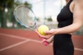 Sports girl is preparing to serve a tennis ball. Close-up of a beautiful young girl holding a tennis ball and racket Royalty Free Stock Photo