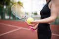 Sports girl is preparing to serve a tennis ball. Close-up of a beautiful young girl holding a tennis ball and racket Royalty Free Stock Photo