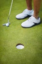 Sports, golf hole and shoes of golfer on course playing game, practice and training for competition. Recreation, grass Royalty Free Stock Photo