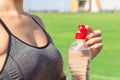 Sports and healthy concept. woman athlete is opening plastic bottle to drink water after training in stadium Royalty Free Stock Photo