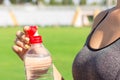 Sports and healthy concept. woman athlete is opening plastic bottle to drink water after training in stadium Royalty Free Stock Photo