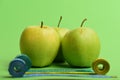Sports and healthy lifestyle symbols. Apples near rolled measuring tapes