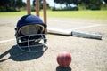 Sports helmet and ball with bat by stumps on pitch Royalty Free Stock Photo