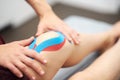 Sports injury kinesio treatment. therapist placing kinesio tape on patient`s knee Royalty Free Stock Photo