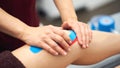 Sports injury kinesio treatment. therapist placing kinesio tape on patient`s knee