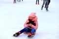 Sports injury, pain in leg, arm, fracture during sports, winter holidays. A girl skates and falls on children skating rink. Dnipro