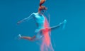 Sports jump. Strong sportive girl gymnast jumping in split in air. Colorful neon light, long exposure. Sport motivation