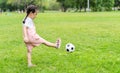 Sports kid. Happy little girl kid kicking a soccer ball, Child plays Royalty Free Stock Photo