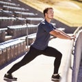 Sports, legs and man stretching at stadium for race, marathon or competition training for health. Fitness, wellness and Royalty Free Stock Photo