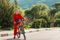 Sports lifestyle and Cycling. A young beautiful smiling woman in sportswear rides a Bicycle. In the background, the road and Royalty Free Stock Photo