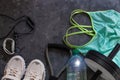 Sports flatlay composition, trendy white sneakers, sport watch, fitness chest expander, ab wheel for abdominal training