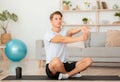 Attractive man doing stretching for hand exercises on mat