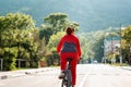 Sports lifestyle. A young woman in sports clothes, riding a Bicycle on an empty road. Rear view Royalty Free Stock Photo