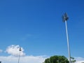 Sports light pole or Stadium Light tower in sport arena on blue sky with clouds. Royalty Free Stock Photo