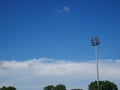 Sports light pole or Stadium Light tower in sport arena on blue sky with clouds. Royalty Free Stock Photo