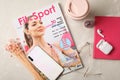 Sports magazine, smartphone and women`s accessories on light table, flat lay Royalty Free Stock Photo