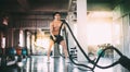 Sports man with battle rope battle ropes exercise in the fitness gym. Fitness, gym, sport, rope, training, athlete, workout,