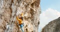 sports man climber climbing on the rock route, making hard move and cliping rope Royalty Free Stock Photo