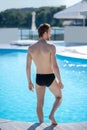 Sports man with his back to camera entering pool Royalty Free Stock Photo